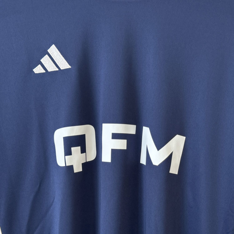 weißes Firmen Logo auf den blauen adidas Trikots