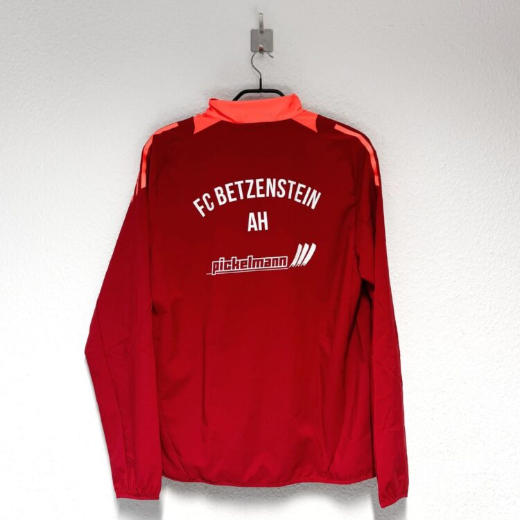 rote adidas Trainingsjacke mit Vereinsnamen und Sponsorenwerbung