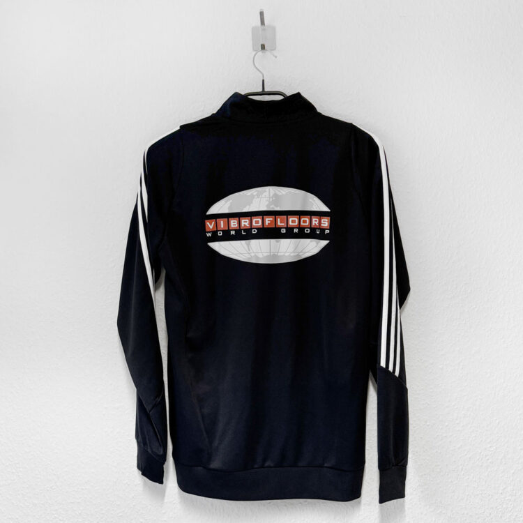 Die schwarzen adidas Trainingsjacken mit Sponsorenlogo Druck auf dem Rücken